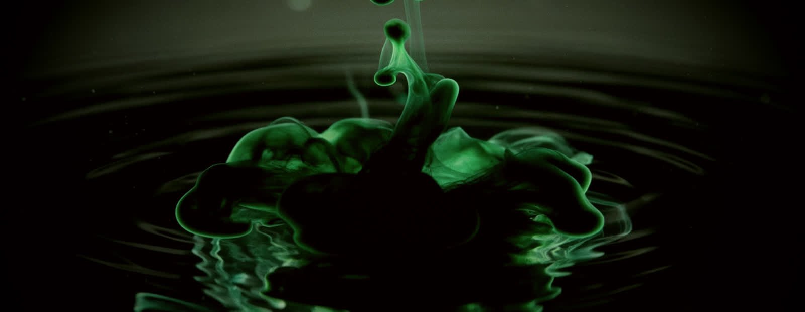 Tinte, die sich langsam in warmem Wasser entfaltet.